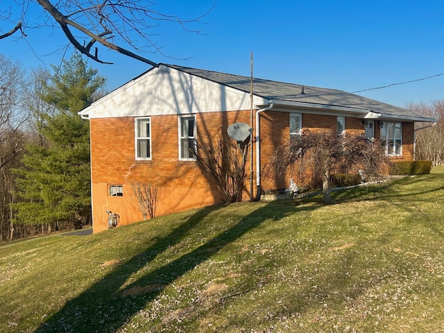 view of property exterior featuring brick siding and a lawn