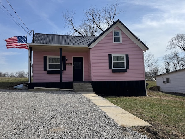 view of front of house featuring a porch, a front yard, and metal roof