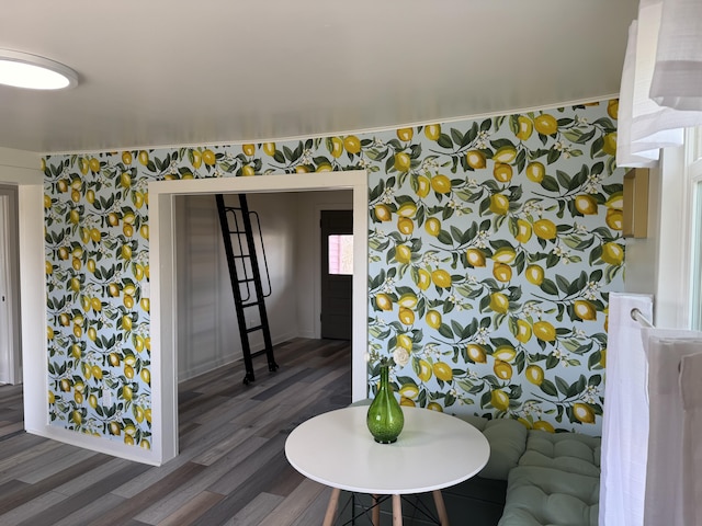 dining area featuring wood finished floors and wallpapered walls