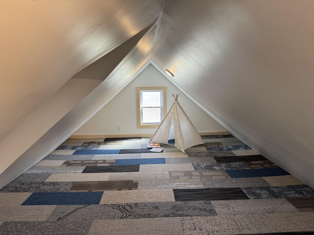 additional living space with vaulted ceiling and carpet floors