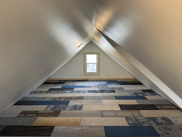 additional living space with carpet flooring, baseboards, and vaulted ceiling