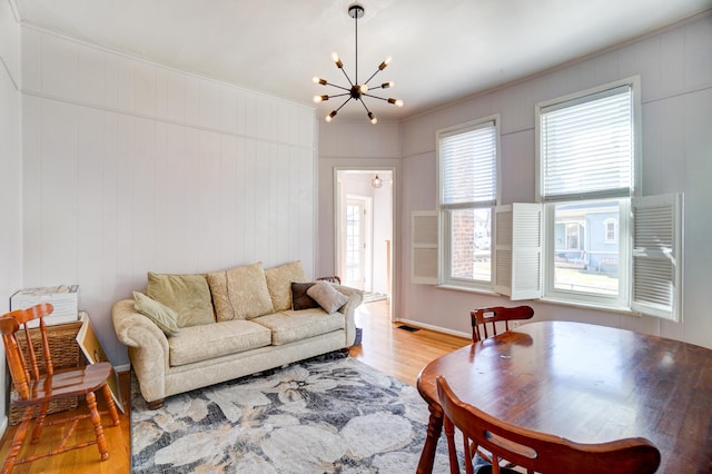 living area featuring an inviting chandelier, wood finished floors, and visible vents