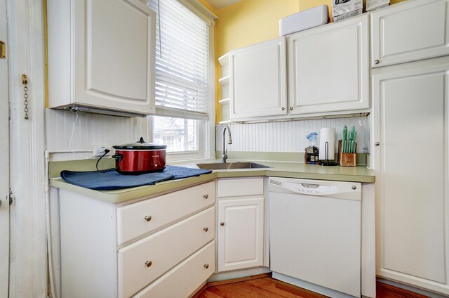 kitchen with dishwasher, white cabinets, and a sink