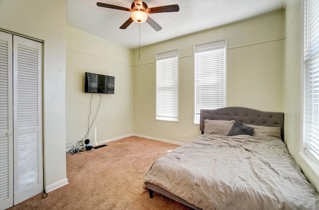 carpeted bedroom featuring a closet, a ceiling fan, and baseboards