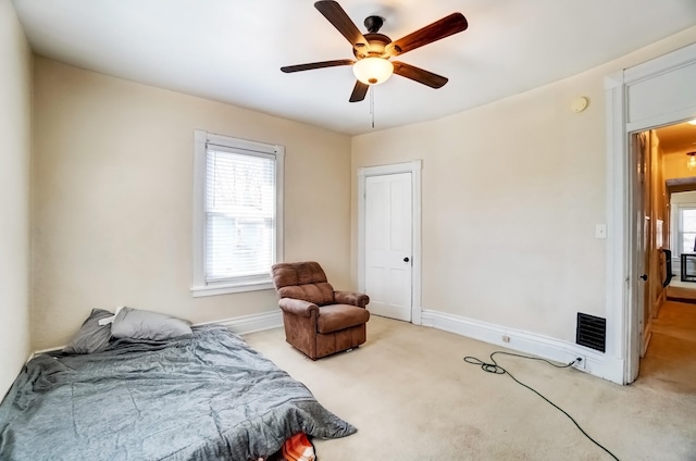 bedroom with light carpet, visible vents, multiple windows, and baseboards