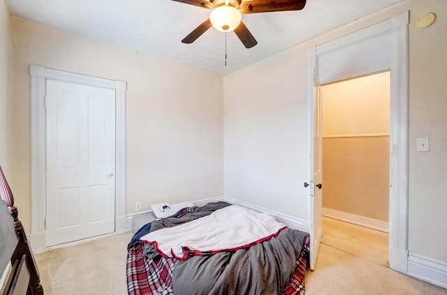 bedroom featuring baseboards, light carpet, and a ceiling fan