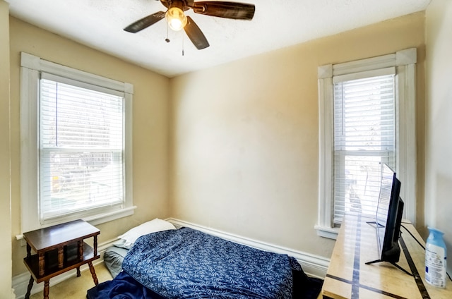 bedroom featuring baseboards and ceiling fan