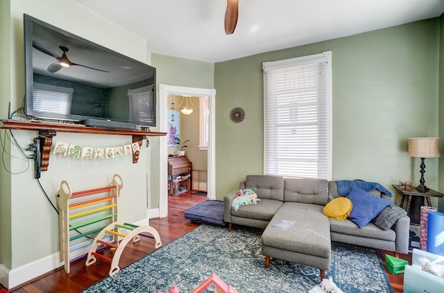 living room with baseboards, wood finished floors, and ceiling fan