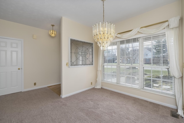 unfurnished dining area with a notable chandelier, carpet flooring, baseboards, and visible vents