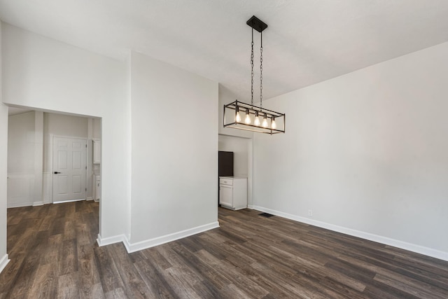 unfurnished dining area featuring visible vents, dark wood-style floors, and baseboards