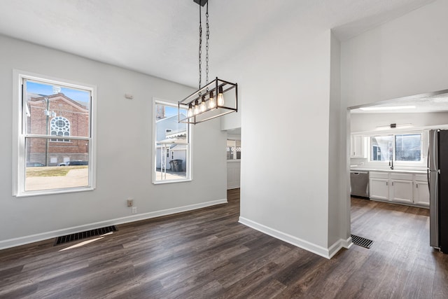 unfurnished dining area with visible vents, baseboards, and dark wood finished floors