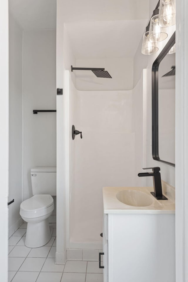 bathroom with tile patterned flooring, vanity, a shower stall, and toilet