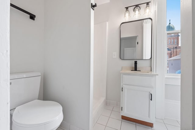 full bath featuring tile patterned floors, toilet, baseboards, walk in shower, and vanity