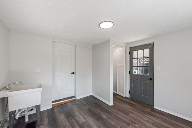 entryway featuring baseboards, a textured ceiling, and dark wood-style floors