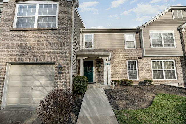 view of front of home featuring brick siding and a garage