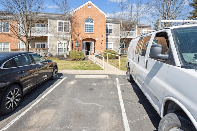 view of front of home featuring uncovered parking and brick siding