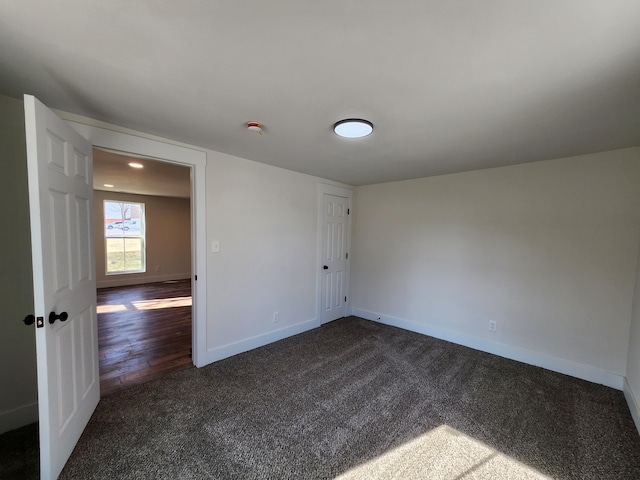 spare room with baseboards and carpet floors