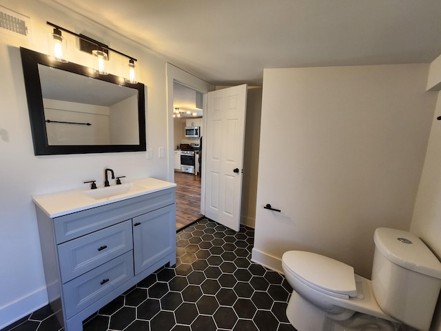 bathroom featuring vanity, toilet, and baseboards