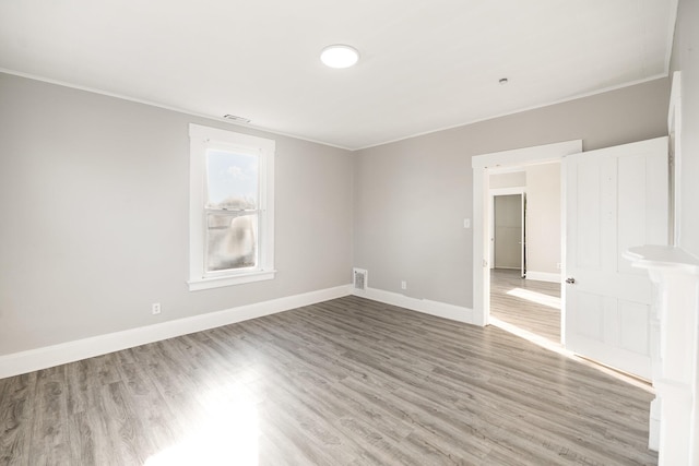 spare room with visible vents, light wood-style floors, and baseboards