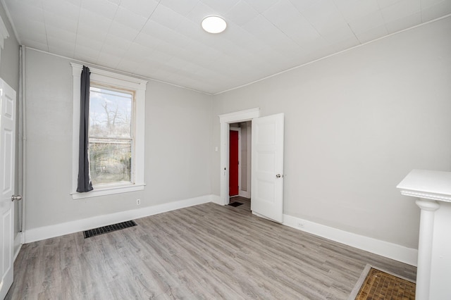 unfurnished bedroom featuring visible vents, baseboards, and wood finished floors