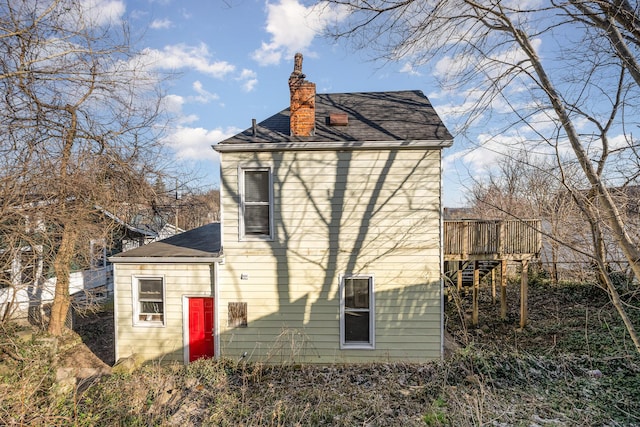 view of side of home with a wooden deck and a chimney