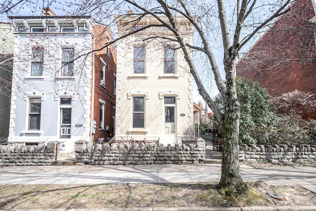 view of front of house featuring brick siding and fence