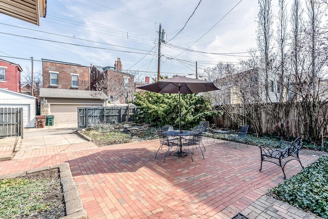 view of patio / terrace featuring an outbuilding, outdoor dining area, a garage, and fence