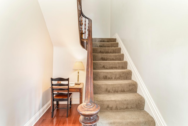 stairs with baseboards and wood finished floors