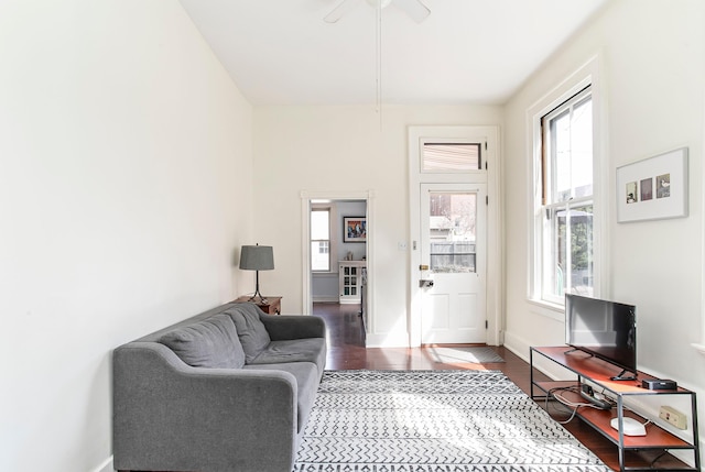 living room with baseboards, wood finished floors, and a ceiling fan