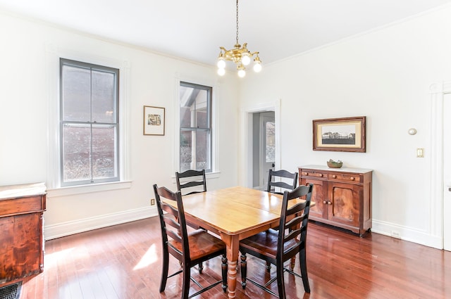 dining room with crown molding, a notable chandelier, visible vents, and dark wood-style flooring