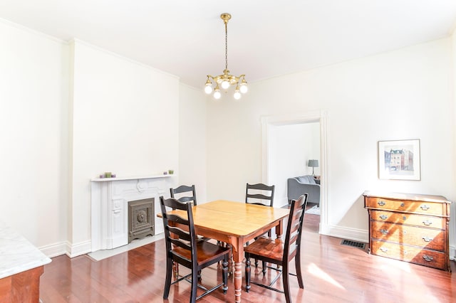 dining area featuring baseboards, wood finished floors, visible vents, and a chandelier