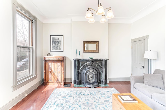 living area with an inviting chandelier, wood finished floors, and baseboards