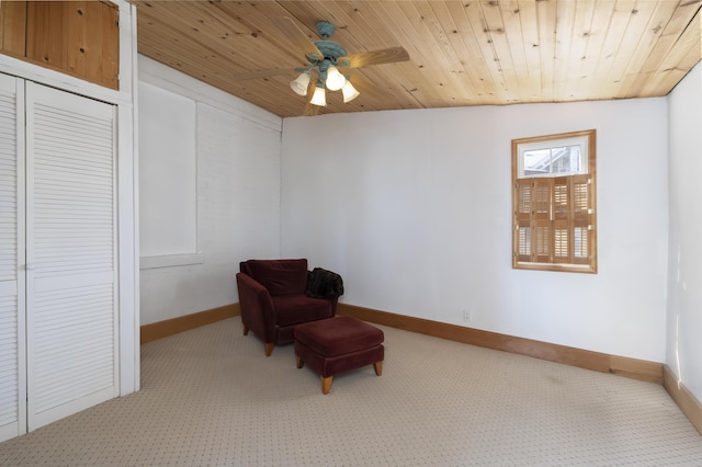 living area featuring wooden ceiling, baseboards, and carpet floors