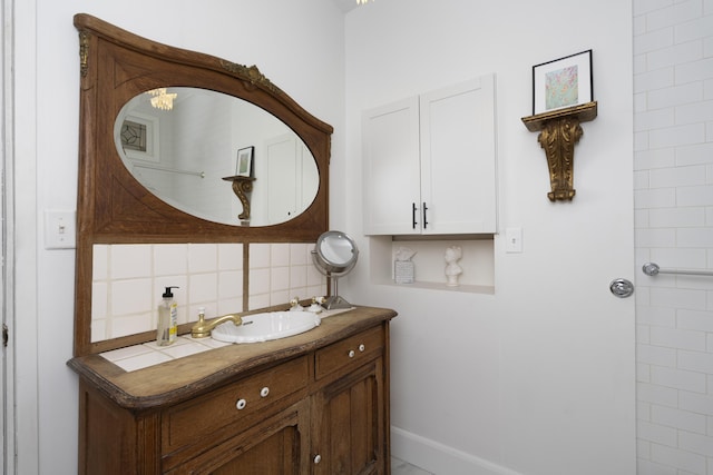 bathroom featuring decorative backsplash, vanity, and baseboards