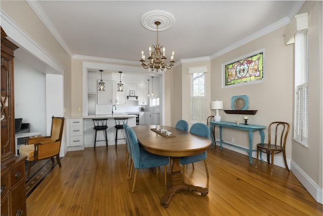 dining area featuring wood finished floors and crown molding