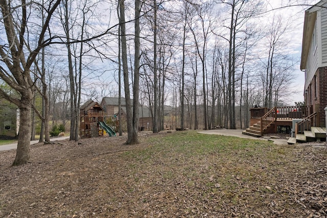 view of yard featuring a wooden deck and a playground