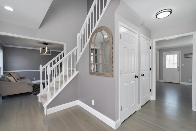 staircase with ornamental molding, baseboards, and wood finished floors