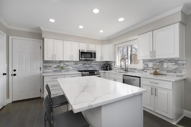 kitchen featuring a sink, white cabinets, light stone countertops, and stainless steel appliances