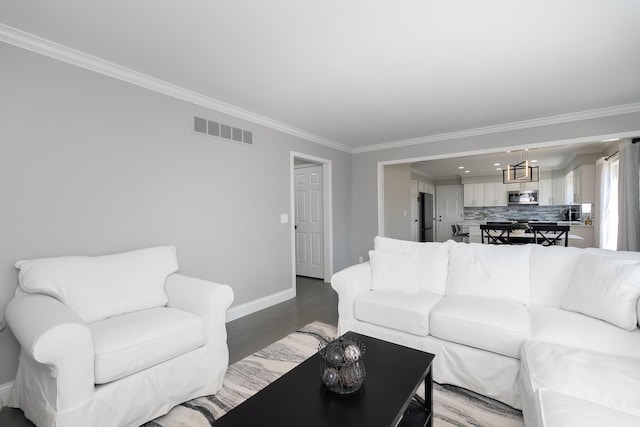 living room featuring light wood-type flooring, visible vents, and ornamental molding