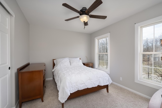 bedroom featuring a ceiling fan, multiple windows, carpet, and baseboards