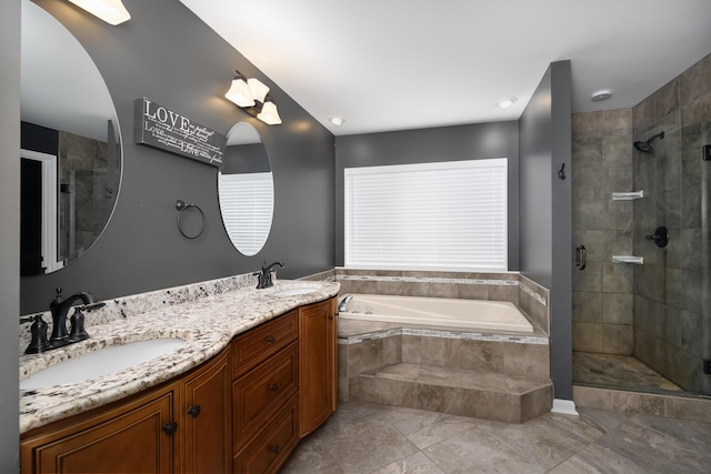 bathroom featuring a bath, a stall shower, double vanity, and a sink