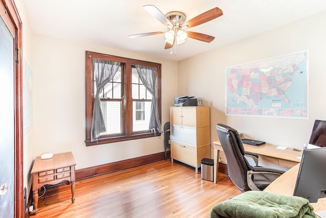 home office with baseboards, a ceiling fan, and light wood-style floors