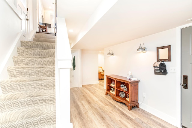 staircase featuring visible vents, wood finished floors, and baseboards