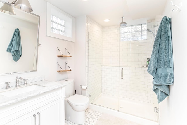 full bathroom featuring toilet, a stall shower, and vanity