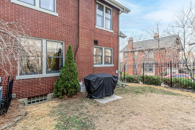 exterior space featuring a yard, fence, and brick siding