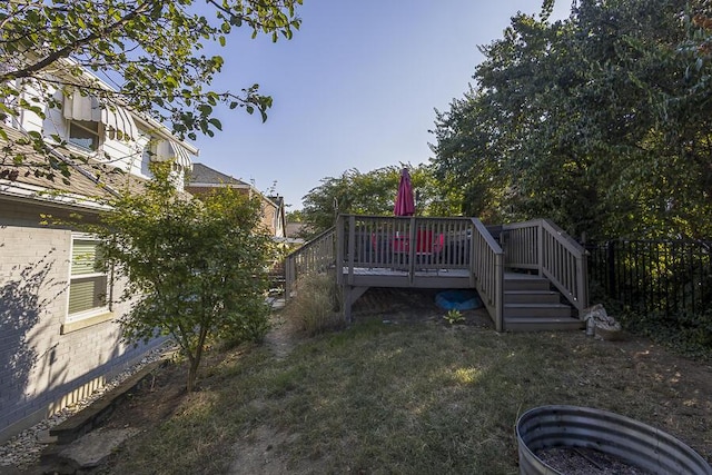 view of yard featuring a wooden deck, stairs, and fence