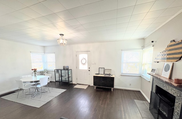 dining room featuring baseboards, a brick fireplace, wood finished floors, and crown molding