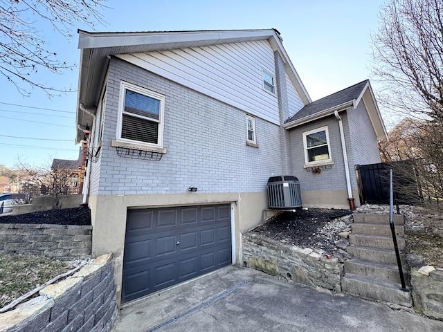 exterior space with concrete driveway, brick siding, and a garage