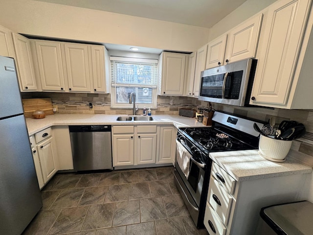 kitchen with a sink, decorative backsplash, light countertops, and stainless steel appliances