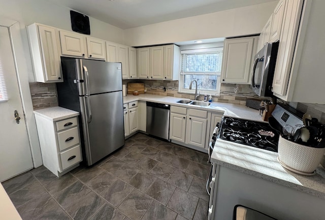 kitchen with backsplash, appliances with stainless steel finishes, and a sink